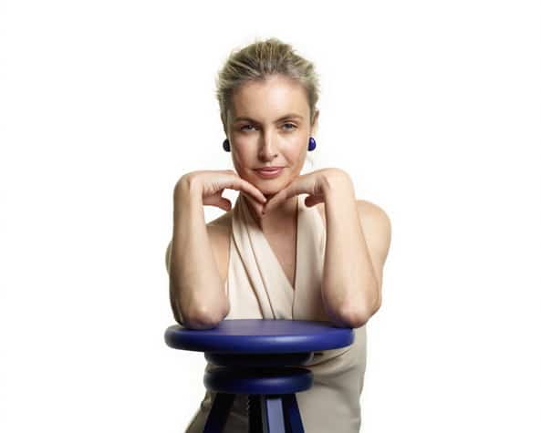 Woman posing with a blue stool.