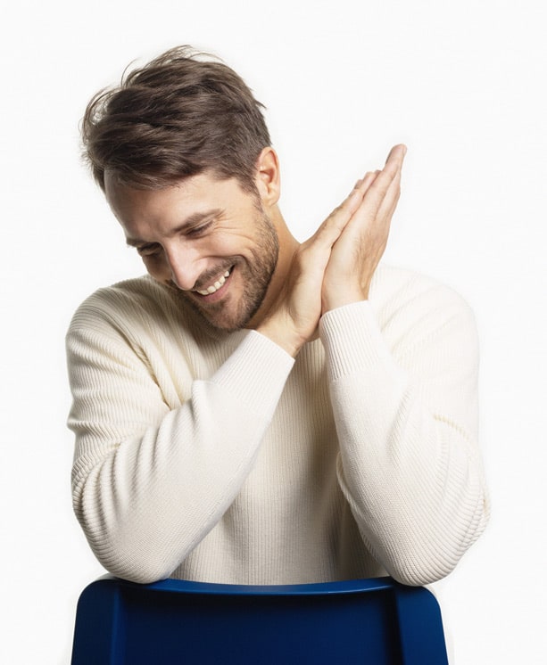 Smiling man with hands clasped together