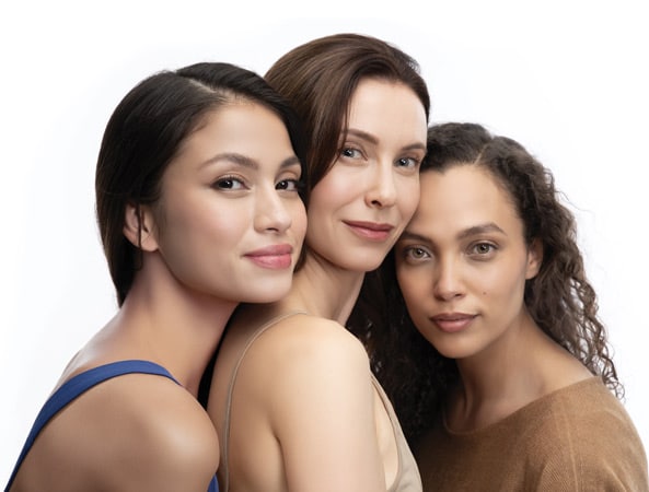 Three women posing together, smiling.